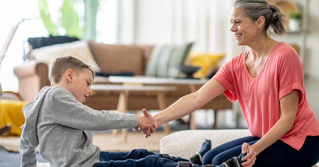 Neurological physiotherapist assisting a patient with adaptive movement patterns in brain injury rehabilitation at home.